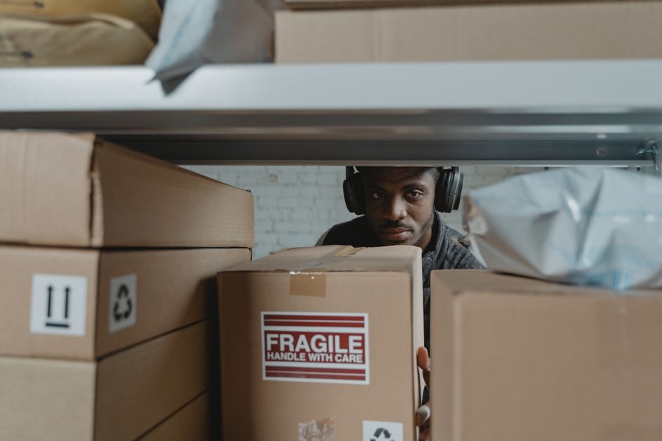 Focused warehouse worker organizes and inspects fragile packages.